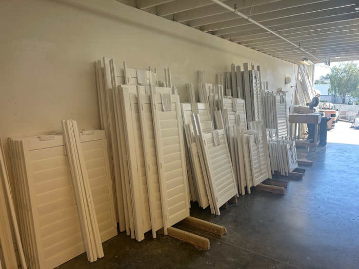 Array of interior and exterior wood and vinyl shutters in various styles, neatly organized at our manufacturing facility in Lake Forest, serving Rancho Santa Margarita and Southern California.